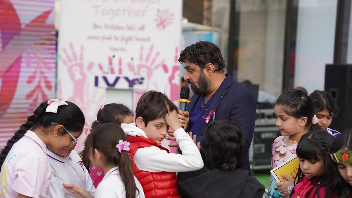 Dr Mohammad Muneeb Khan talking with pupils during a school breast-cancer awareness day.