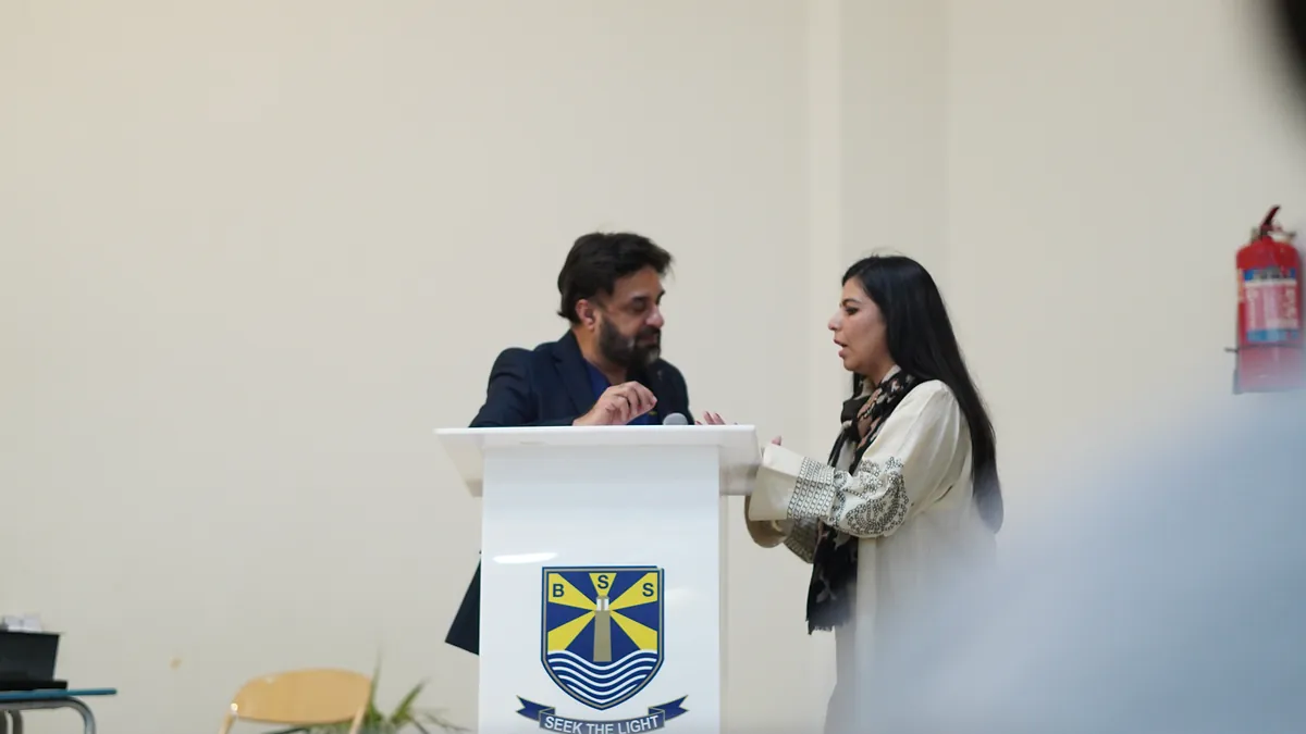 Dr Mohammad Muneeb Khan at the Beaconhouse School System lectern, its crest and Seek the Light motto in view.