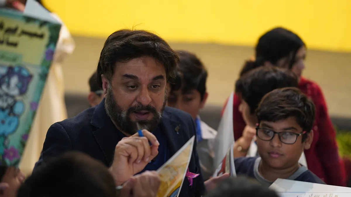 Dr Mohammad Muneeb Khan talks a pupil through a page of the Killing Cancer Kindly prevention comic.