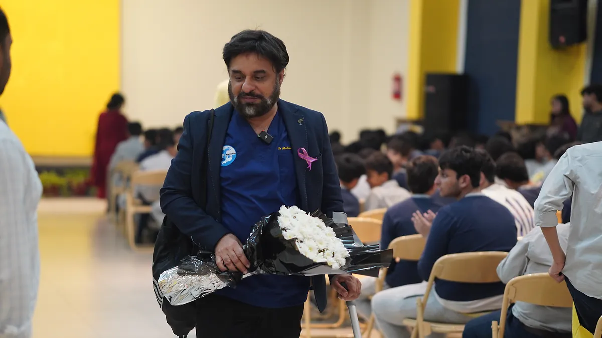 Dr Mohammad Muneeb Khan carries a bouquet through the school hall after the cancer-prevention assembly.