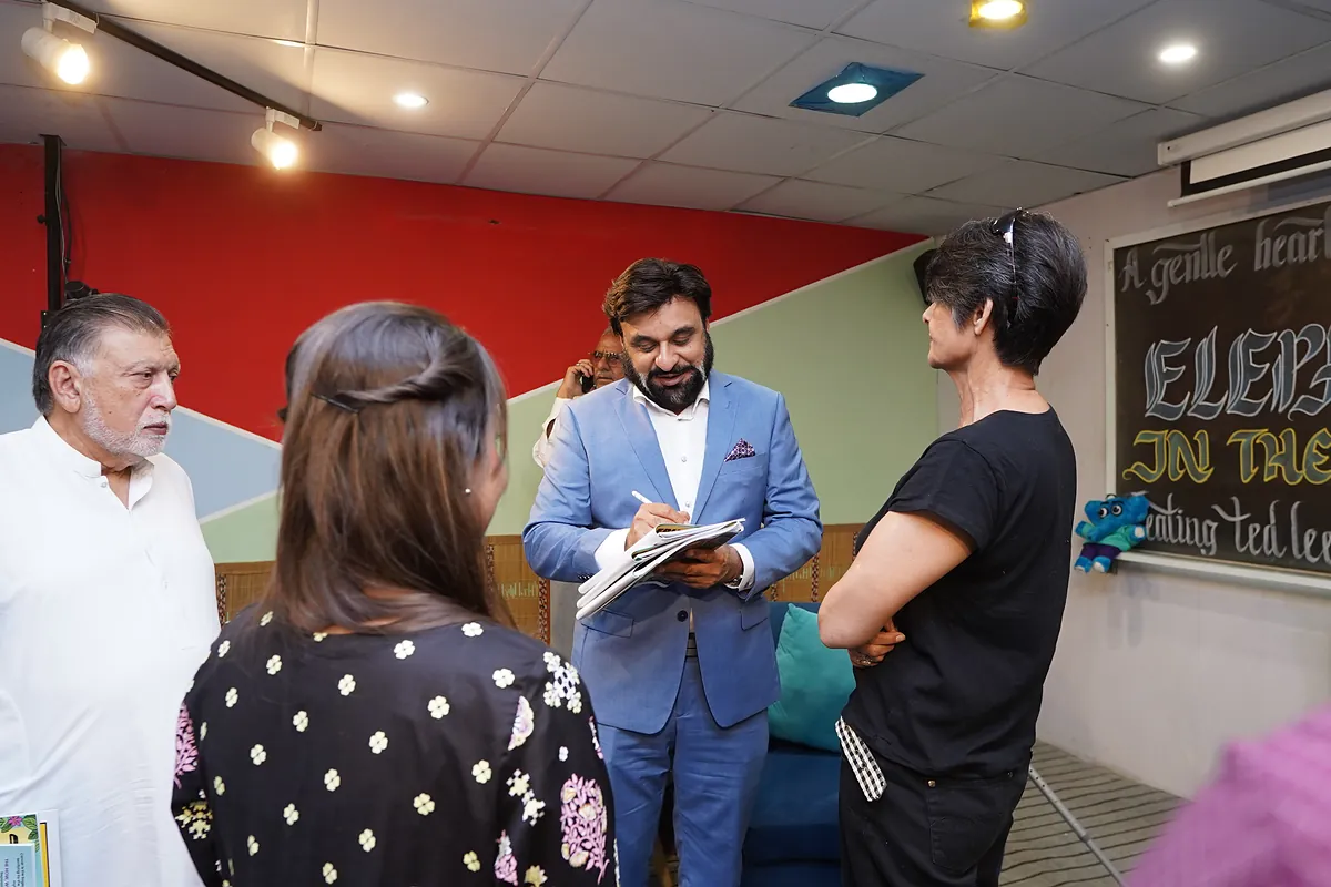 Dr Mohammad Muneeb Khan talks with guests over a copy of the comic after the launch.