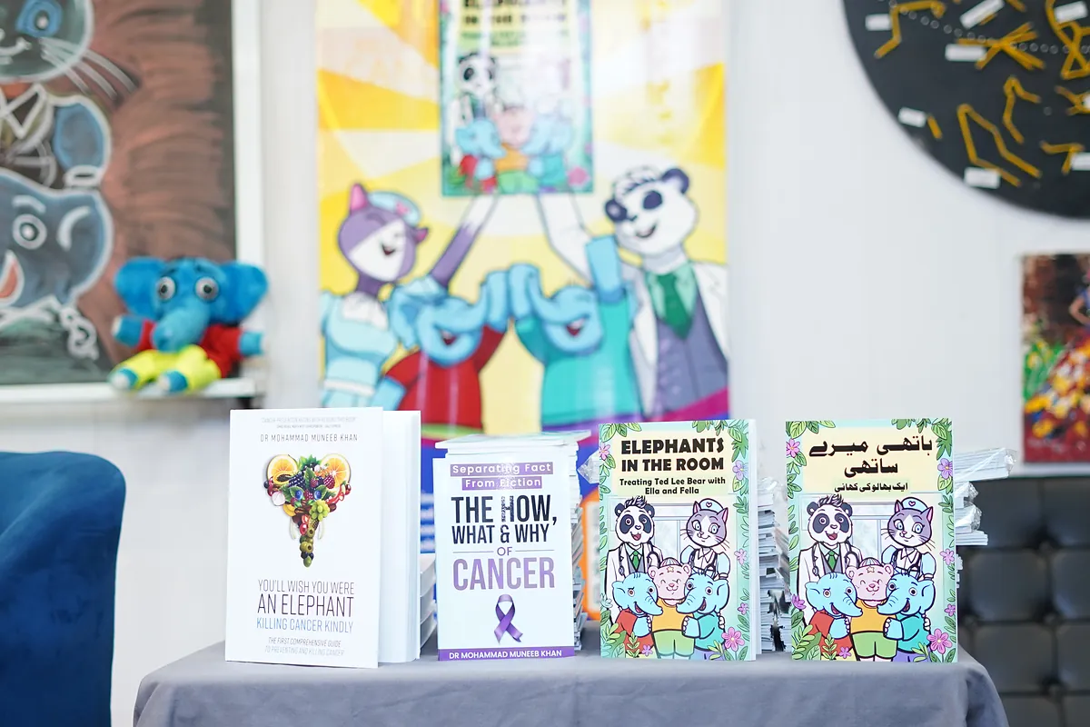 The English and Urdu editions of Elephants in the Room displayed beside Dr Khan's cancer-prevention books.