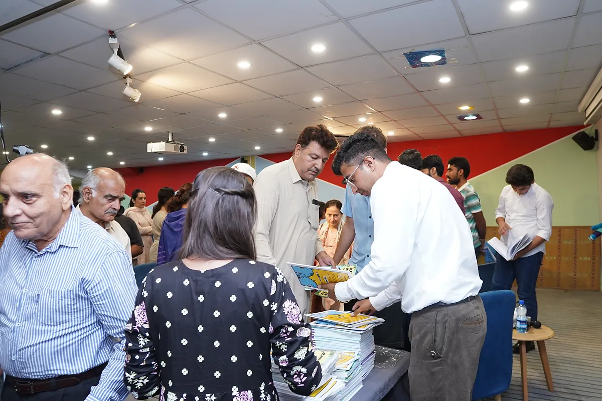 Families take copies of Elephants in the Room from the display table at the launch event.